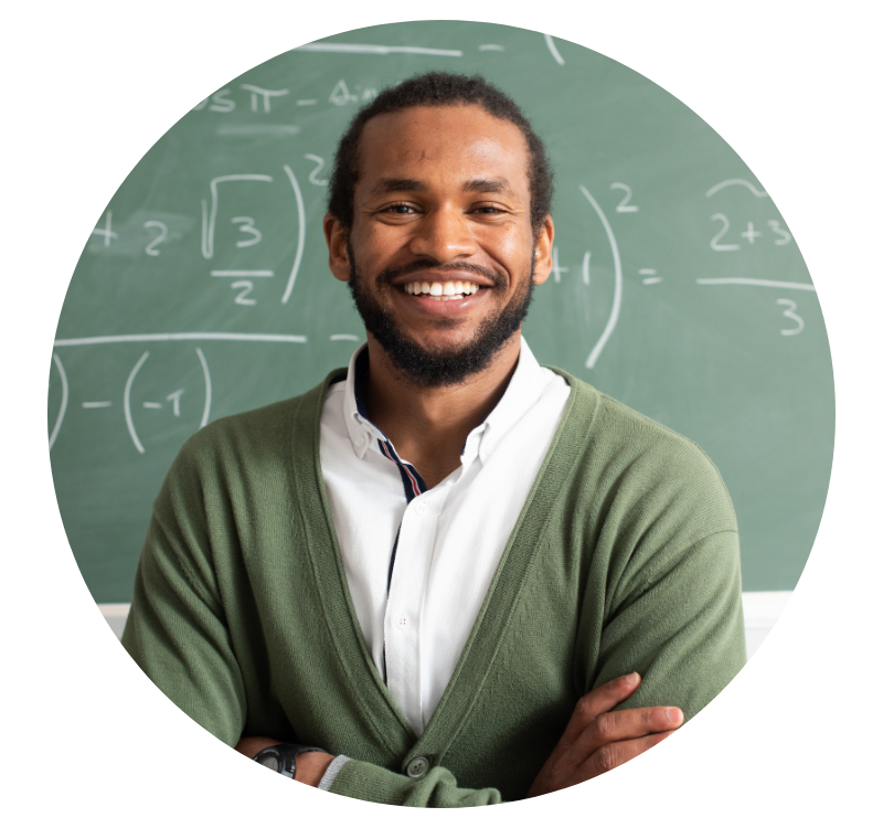Kevin K, Counselor school teacher and class advisor smiles in front of chalk board